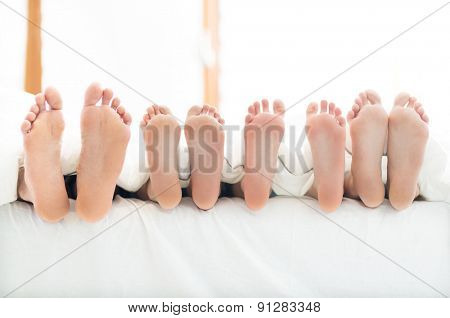 Feet of family in bed
