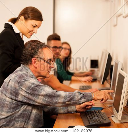Group of adults learning computer skills. Intergenerational transfer of knowledge.