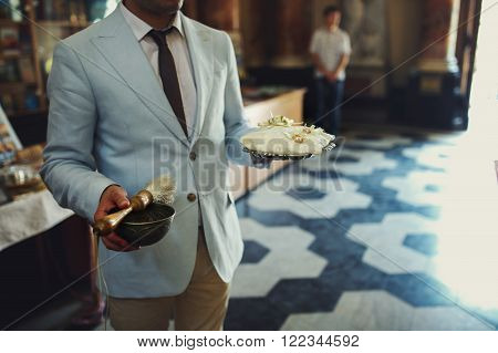Stylish Bestman Holding Cushion With Two Golden Wedding Rings