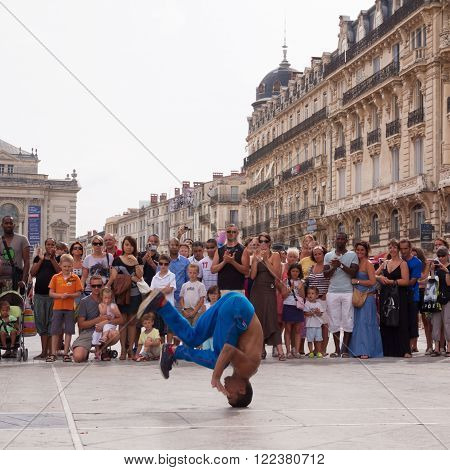 Montpellier, France - July 12: Street performer breakdancing on main square in front of the random crowd on July 12, 2011 in Montpellier, France.