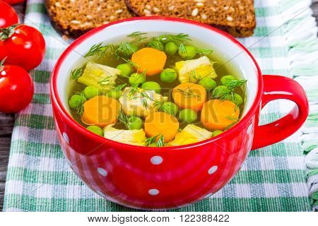 Chicken soup in a red bowl close-up