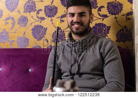 Close-up Of Man Smoking Traditional Hookah Pipe