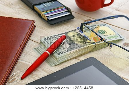 a bundle of money and other items on the table