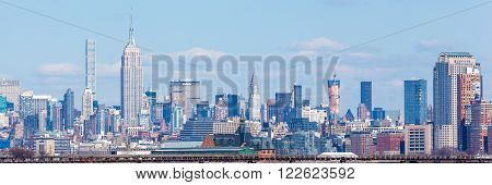 JERSEY CITY NJ - MARCH 6: A view of Midtown Manhattan featuring the Empire State Building and 432 Park as seen from Liberty State Park on March 6 2016. The CNJRR terminal also at Liberty State Park is seen in the foreground.
