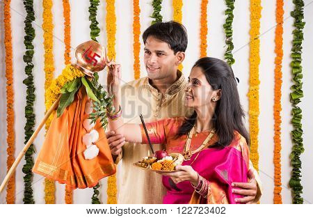 smart indian couple in traditional wear performing gudhi padwa puja, asian couple & puja thali, indian young couple with puja or pooja thali, hindu new year gudhi / gudi padwa, isolated on white