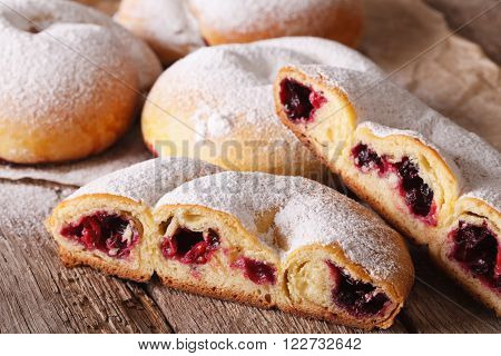 Cut ensaimada bun with berries and powdered sugar close-up. horizontal