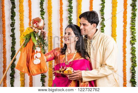 smart indian couple in traditional wear performing gudhi padwa puja, asian couple & puja thali, indian young couple with puja or pooja thali, hindu new year gudhi / gudi padwa, isolated on white