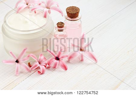 Floral cosmetic facial cream, bottles with aroma oil, hyacinth flowers. Natural beauty treatment.