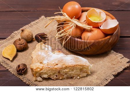Eggs and pie on a sacking. One egg is broken rural style a close up