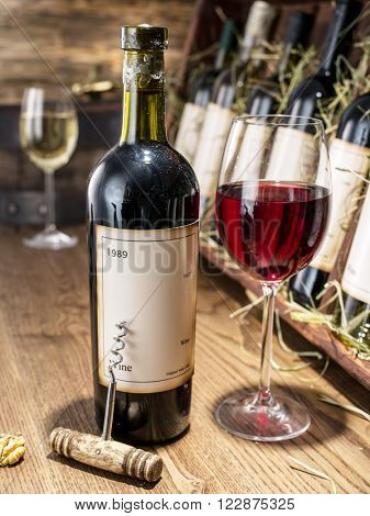 Glass of wine and wine bottle. Wine testing at the storage.