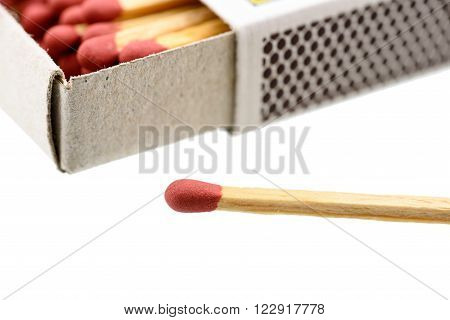 Matchbox, a small paperboard box enclosing a quantity of matches in the interior tray and having a coarse striking surface on the exterior. With a matchstick outside box isolated on white background.