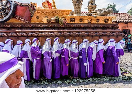 Antigua Guatemala - March 20 2016: Float bearers called cucuruchos carry float with Jesus in Palm Sunday procession in colonial town with most famous Holy Week celebrations in Latin America.