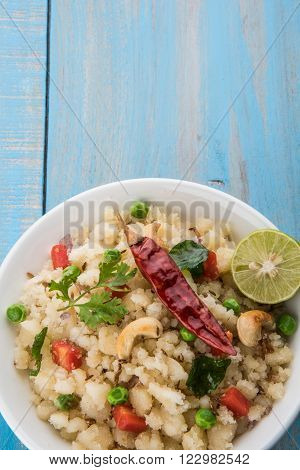 Rava Upma - Popular south Indian breakfast wiih semolina and vegetables, selective focus, Upma or upama is a South Indian breakfast, cooked from dry roasted semolina. seasonings of vegetables