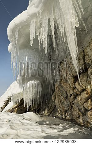 Huge icicles on rocks. Beautiful winter landscape in the Lake Baikal.