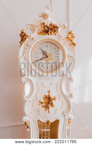 Grandfather's white vintage clock on beige background