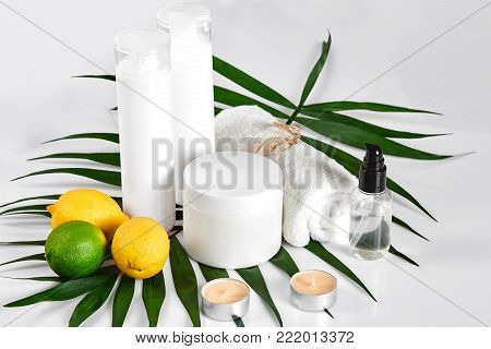 White bottles and two whole lemon and lime isolated on white background. The concept for advertising cosmetics. Still life. Copy space