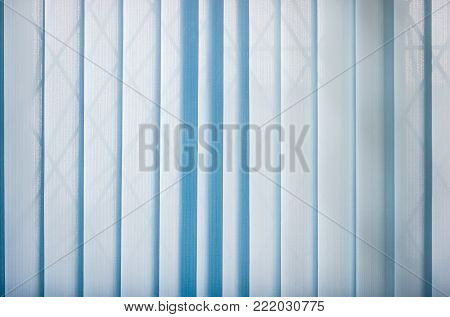 Background of the blue vertical blinds made with stiffened fabric in closed position