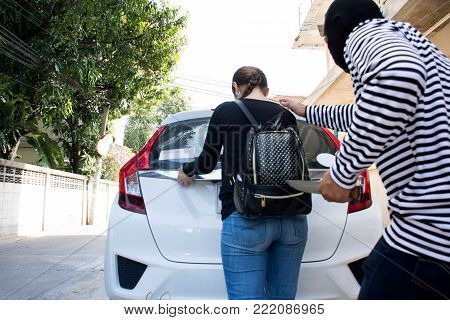 Male robber robbing a lady handbag threatening with knife to young woman,criminal concept