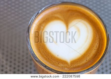 Top view of cortado coffee in a glass with the foam in shape of heart