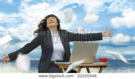 businesslady avec ordinateur portable fonctionne à côté d'un lac. Papier vole autour. Mot clé unique pour ce c