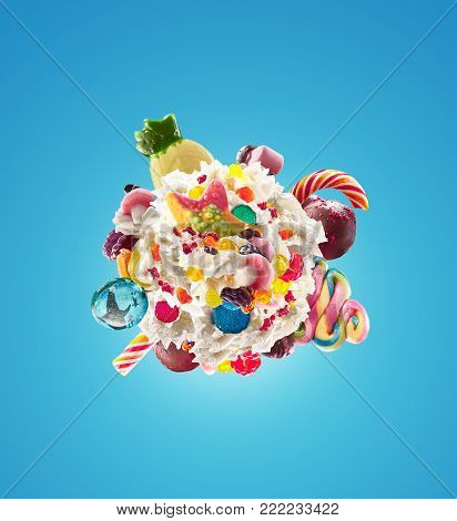 Milk shake with sweets and whipped cream, round form top view. Crazy freakshake food trend. Top view of whipped cream, full of berry and jelly sweets, chocolate candy. Colorful whipped cream concept. Monster shake, freak shake concept isolated