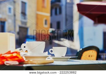 Coffee Cups On Table Of Cafe Or Restaurant Of Small Typical Village In Sardinia, Italy