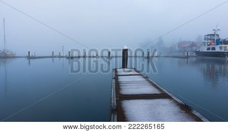 An empty boat dock on a cold, misty morning