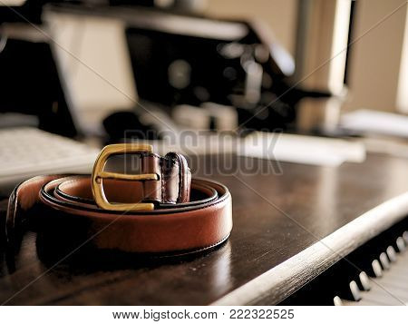 Brown Leather Belt on Wooden Desk with Bokeh