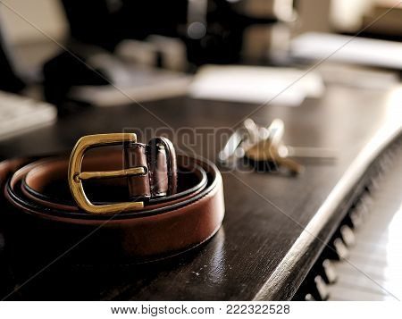 Leather Belt on Dark Wooden Desk with Keys