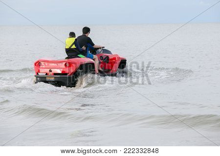 A man and his son driving amphibious car into the sea