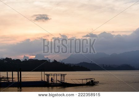 sunset landscape lake with siluate man and boat