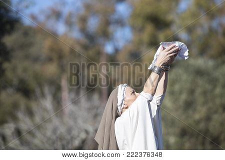 Alcuescar, Spain - December 17th, 2017: Reenactment of Iberian Goddess Ataecina ritual. Priestess rising arms with offering. Performed by Lusitania Romana Group