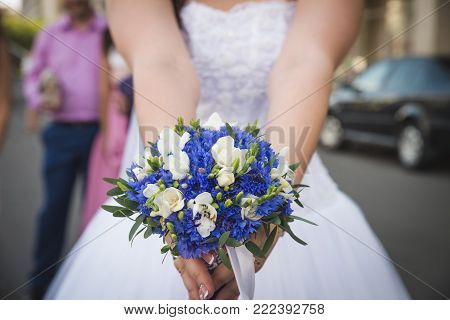 bride with flowers in hand outdoors. wedding