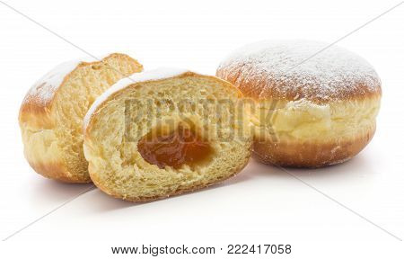 Two doughnuts (Sufganiyah) one cut in half with apricot jam isolated on white background fresh baked with powered sugar