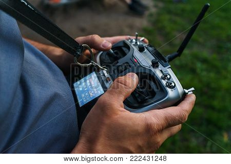 man holds a remote control during the flight control of a sports drones, a scale model of a car. modern technologies and entertainment