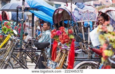 Kathmandu, Nepal - 06 October 2017: Rickshaw driver stand among other rickshaw and waits for clients