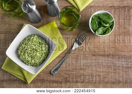 Dish with tasty spinach risotto on table, top view