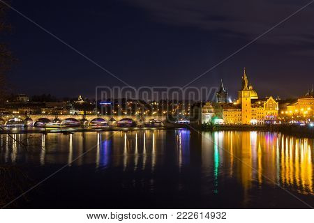 Beautifull night view of the Charles Bridge, the Old Town Bridge Tower, and the Old Water Tower, the Smetana Embankment and the Prague Beer Museum in Czech Republic New Year's Eve.