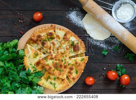 Khachapuri with cheese on a dark wooden table. Traditional Imeretian tortillas. Georgian national cuisine. The top view