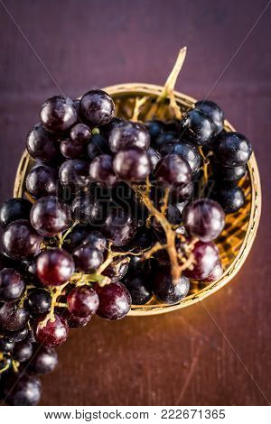 Close Up Of Grapes,vitis Vinifera In A Basket On A Brown Wooden Surface.
