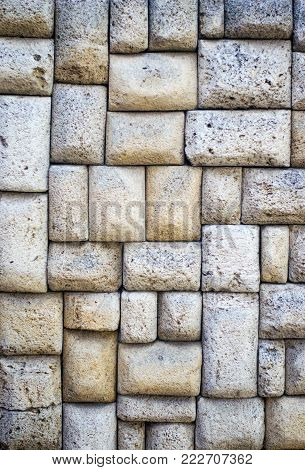 The texture of the stone wall. Stone in the section. Limestone. Granite. Marble. Coquina. Background. Stone floor. Pebbles. Macadam.
