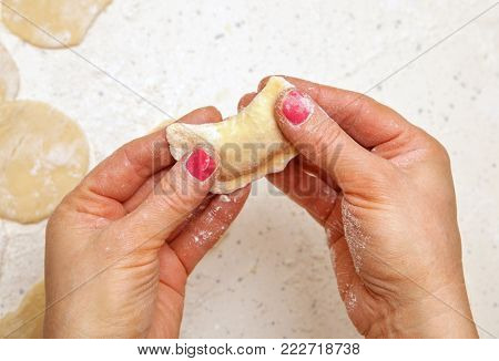 close-up, hands of chef who prepares dumplings from dough