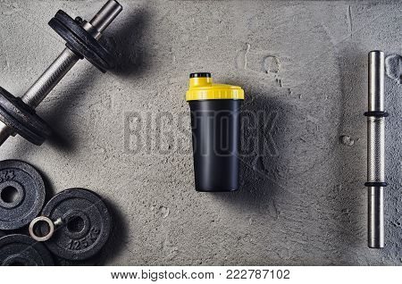 Fitness or bodybuilding concept background. Product photograph of old iron dumbbells on grey, conrete floor in the gym. Photograph taken from above, top view with lots of copy space