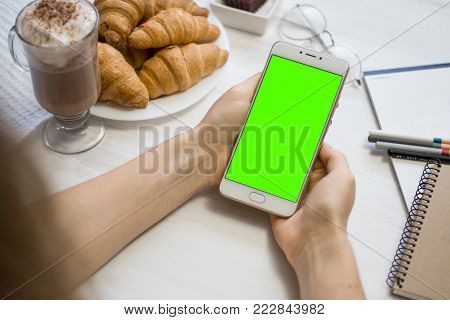 Beautiful girl holding a smartphone in the hands of a green screen green screen, hand of man holding mobile smart phone with chroma key green screen on white background, new technology concept