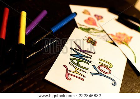 Thank you note and Valentine's card symbolic creativity, spring, art with colored pens on wood desk background to say thank you to business clients, employees inspire fun activity and springtime love
