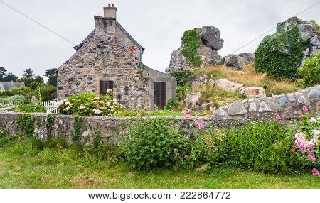 travel in France - typical stone Breton house with garden in Plougrescant town of the Cotes-d'Armor department in Brittany in rainy summer day