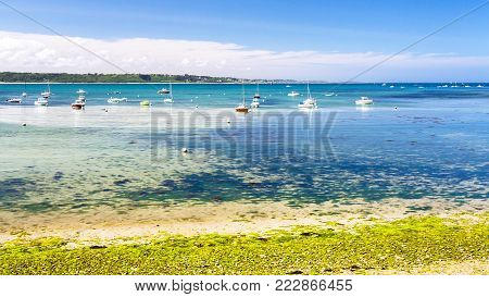 travel to France - boats in bay Anse de Perros of English Channel near Perros-Guirec commune on Pink Granite Coast of Cotes-d'Armor department in the north of Brittany in sunny summer day