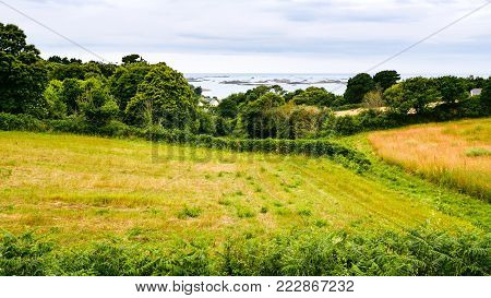 travel to France - harvested field on Launay bay of Atlantic coast in Ploubazlanec commune of Paimpol region in Cotes-d'Armor department of Brittany in summer eveining