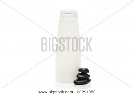 Envases de productos cosméticos y Spa piedras negras aisladas en blanco