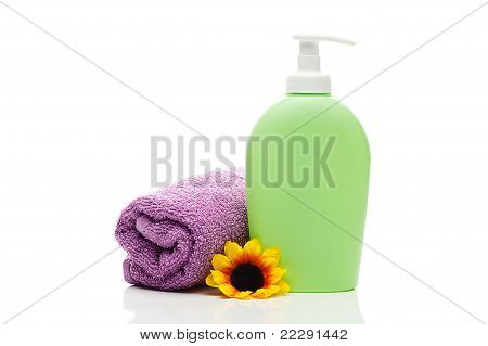 Envases cosméticos, toalla y flor aislado en blanco